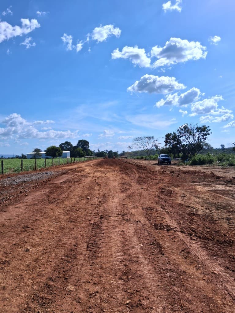 Caminhonete de apoio em via de terra nivelada durante execução de obra